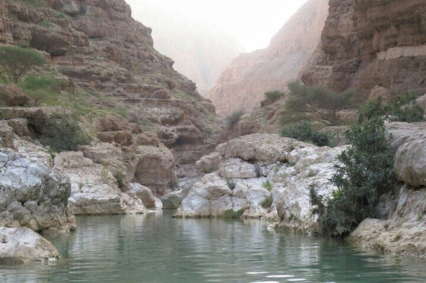 Een kloof met een rivier, rotsachtig terrein en schaarse begroeiing. 2