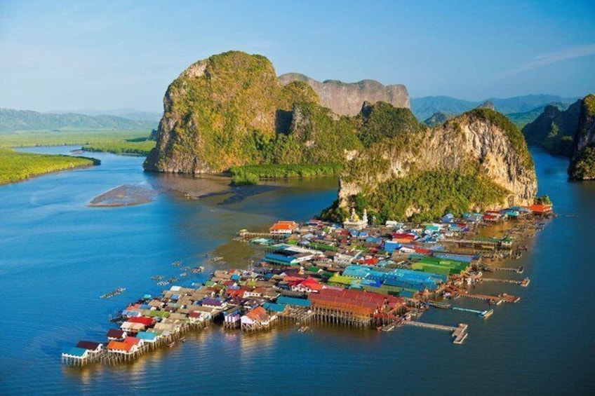 A coastal village with colorful houses and boats, surrounded by large limestone karsts. 3