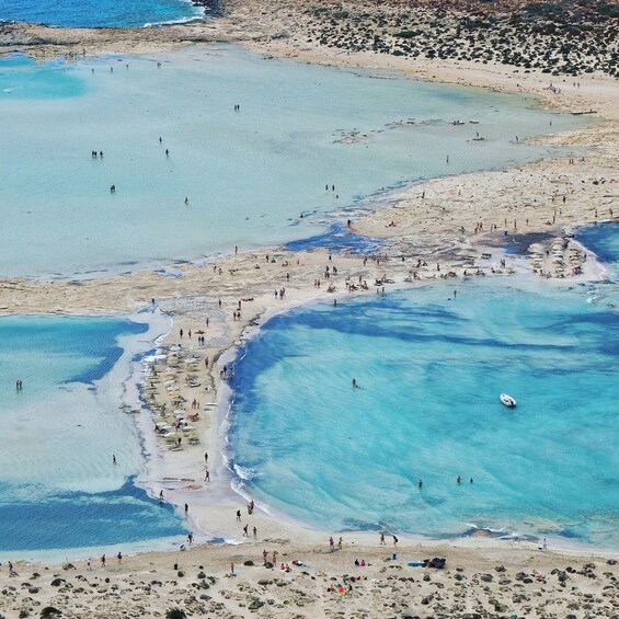 A coastal area with clear blue waters, sandy beaches, and rocky outcrops. 4