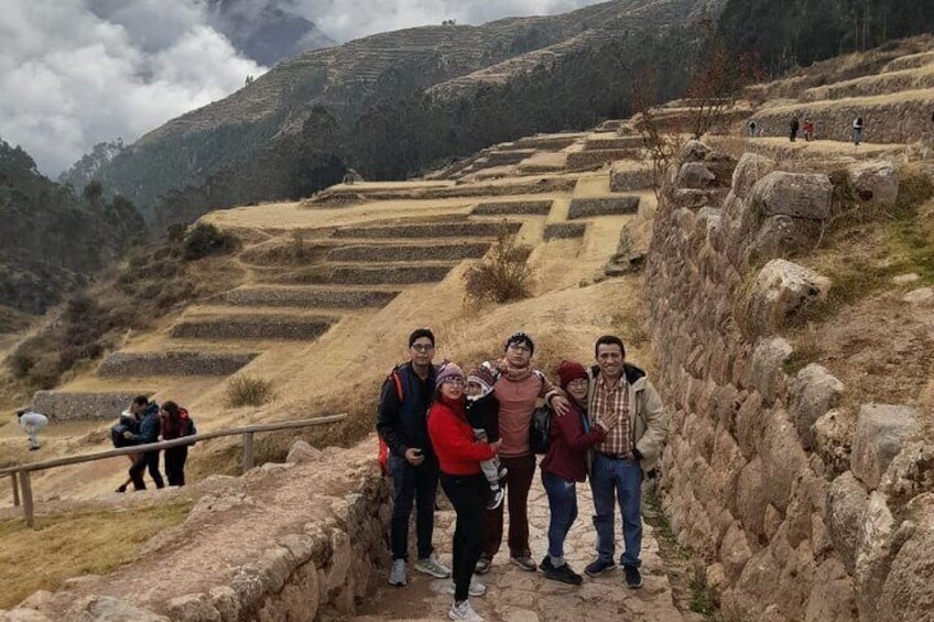 A group of people standing on a stone pathway with terraced fields in the background. 2