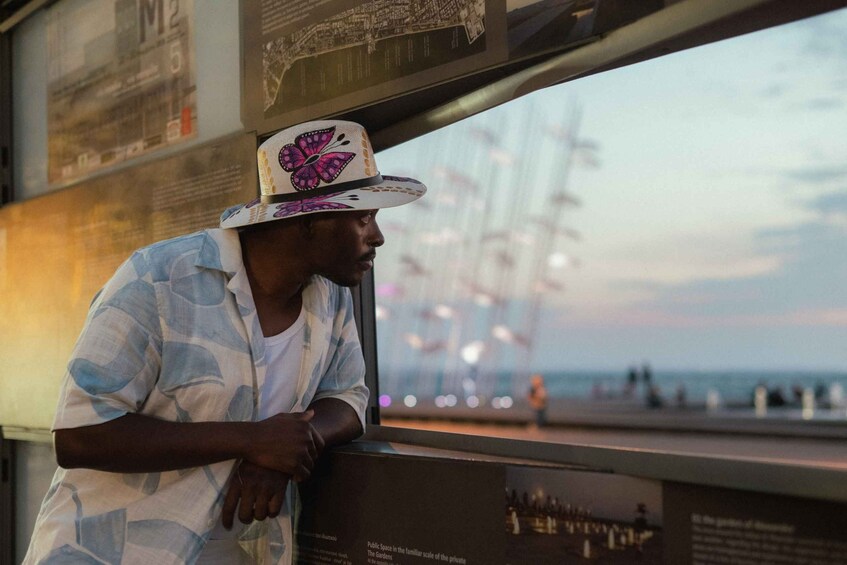 A person leaning on a railing with a cityscape and a body of water in the background. 3