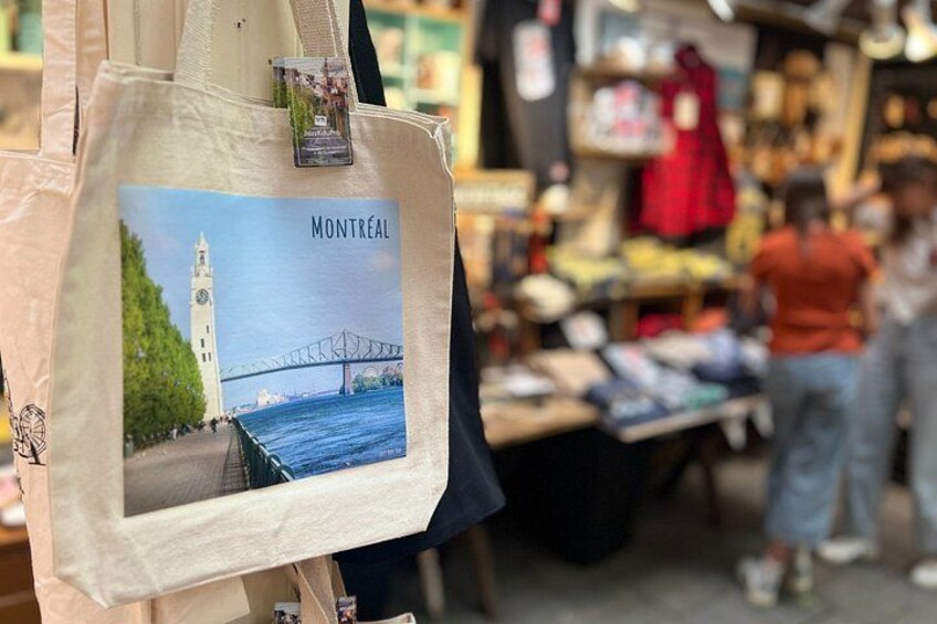 Un puesto de mercado con una bolsa que muestra una imagen de un puente y la palabra 'MONTREAL'. 5
