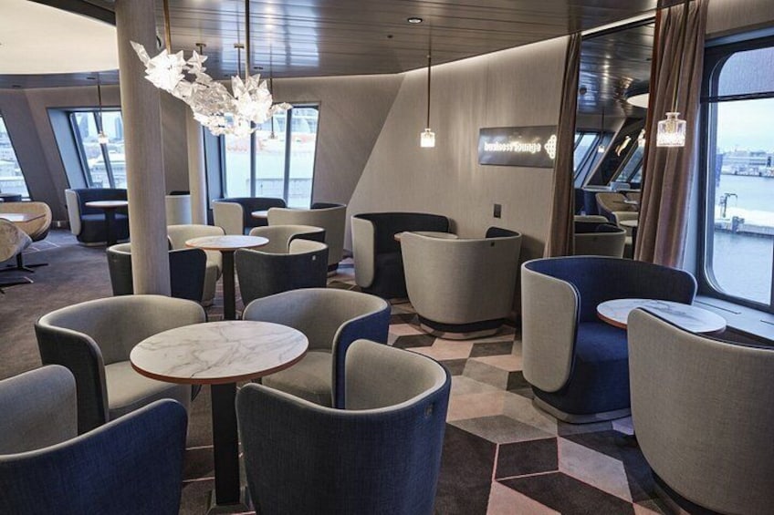 A modern lounge with round tables and comfortable seating. 4
