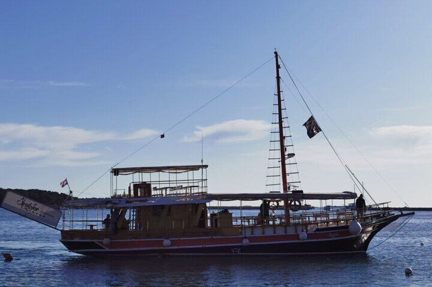 En segelbåt med en hög mast och en flagga låg förtöjd vid en brygga. 4
