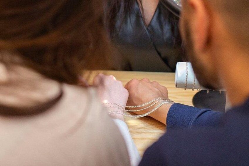 Une personne portant une chemise bleu foncé, assise à une table en bois devant un microphone. 4