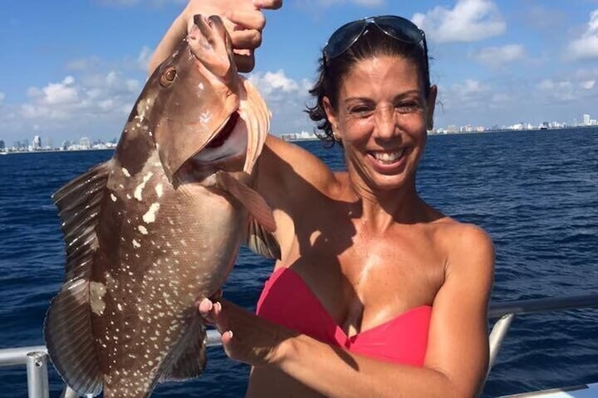 Eine Person hält einen Fisch, im Hintergrund ist eine Stadtansicht zu sehen. 2