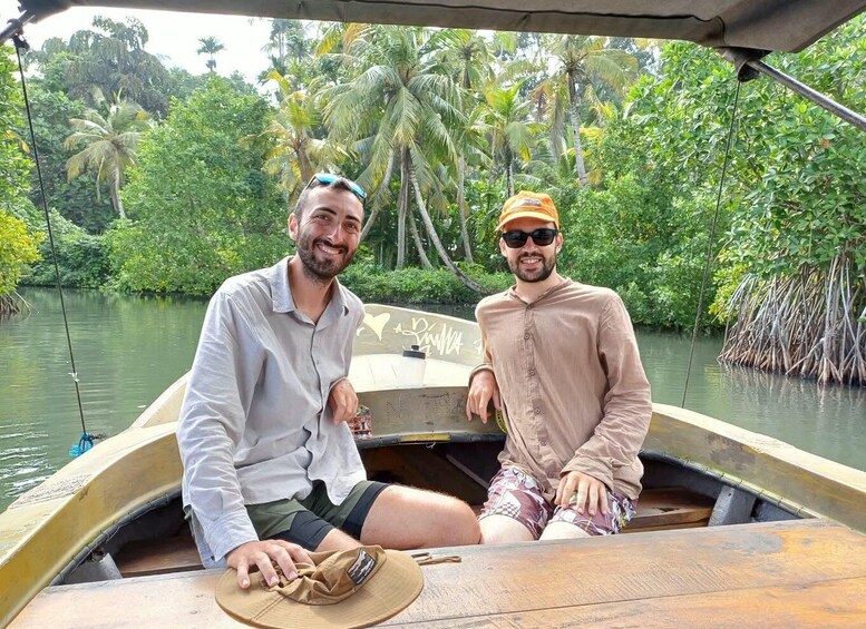 Two people on a boat in a river surrounded by lush greenery. 1