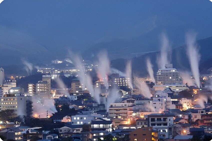 A cityscape at dusk with buildings and smoke plumes. 4