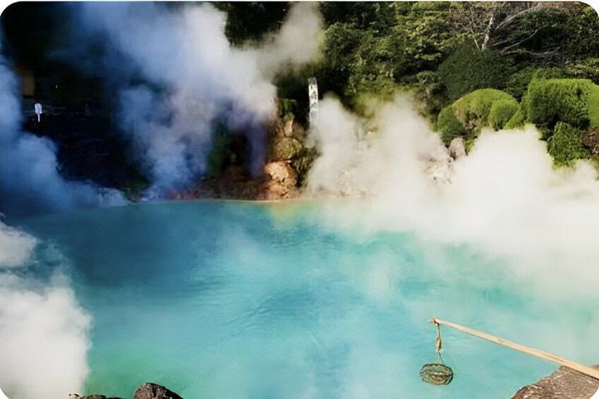 A hot spring with steam rising from the water, surrounded by lush greenery. 3