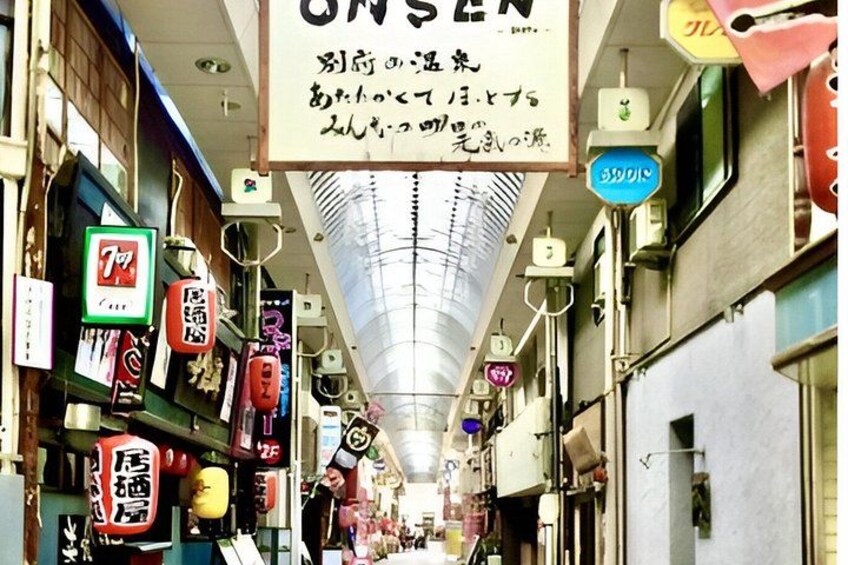 A narrow alley with various shops and signs, including a prominent 7-Eleven sign. 2