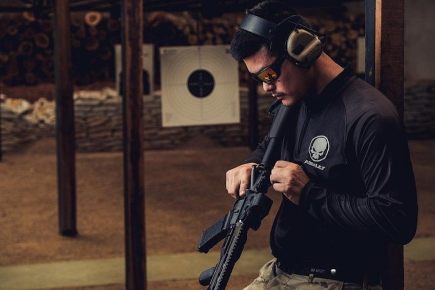 Une personne qui vise une cible avec un fusil dans un stand de tir intérieur. 1