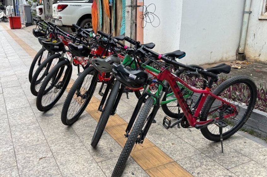 A row of bicycles parked on a tiled sidewalk. 2