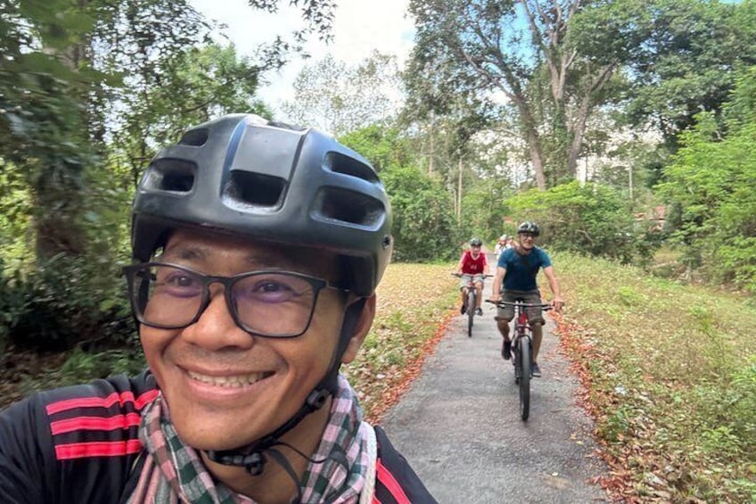 A person on a bicycle on a path surrounded by greenery. 3