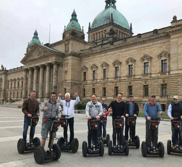 A group of people on segways in front of a large historic building with domed roofs. 4
