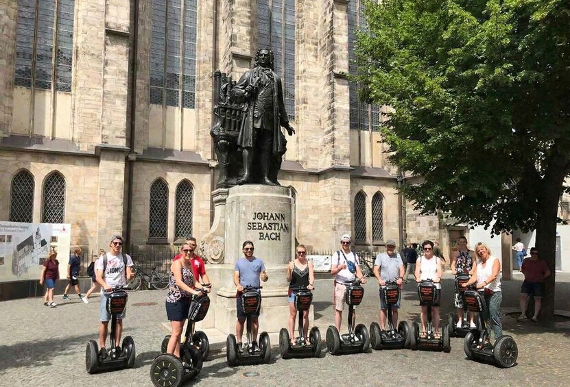 A group of people on segways in front of a statue of Johann Sebastian Bach. 3