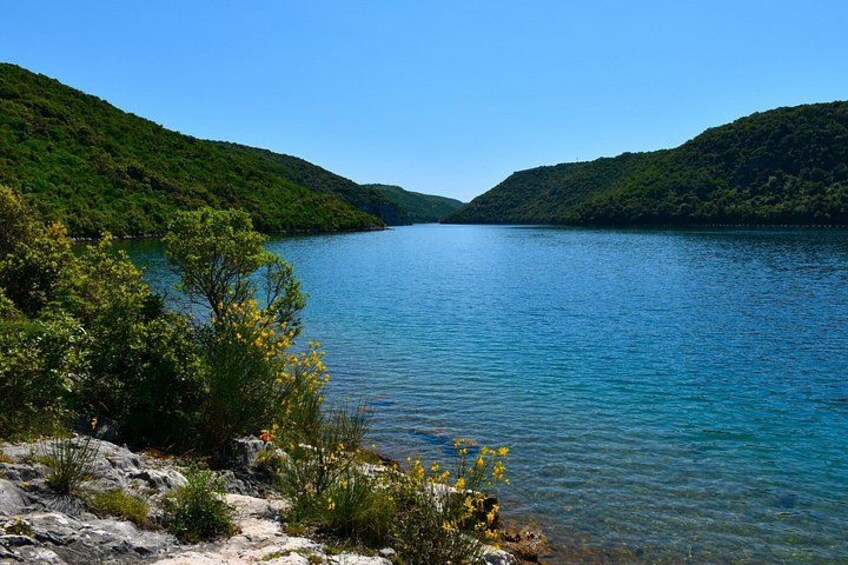 A clear lake surrounded by green hills. 1