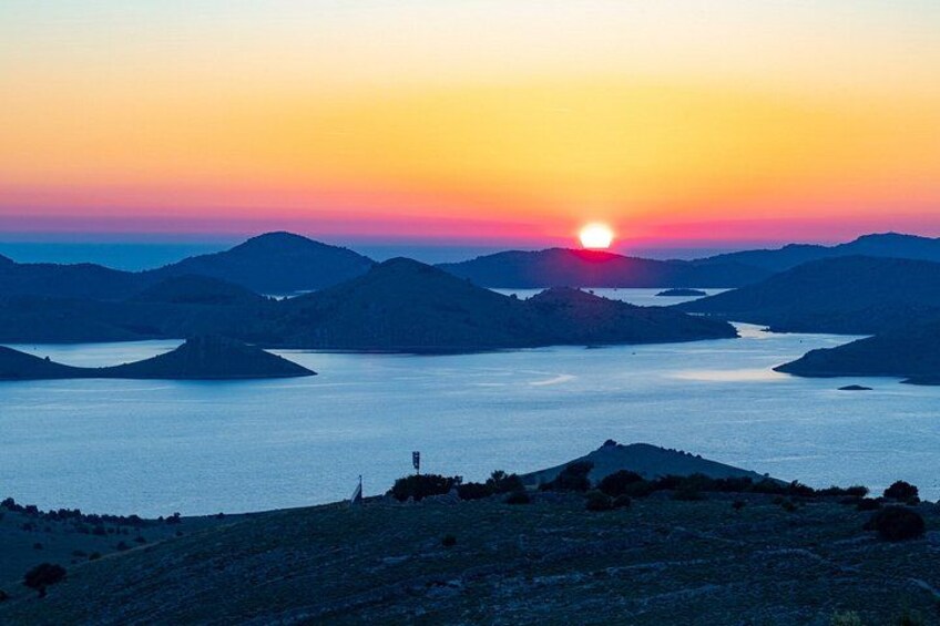 A sunset over a lake surrounded by hills. 3