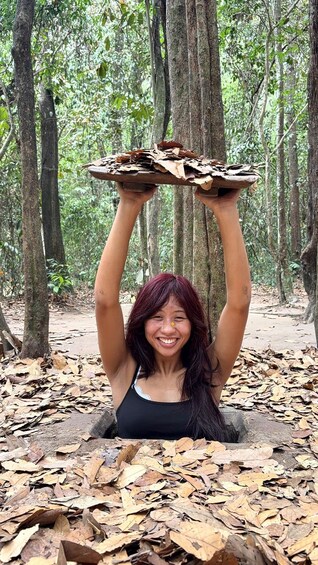 A person holding a tray of leaves in a forest. 4