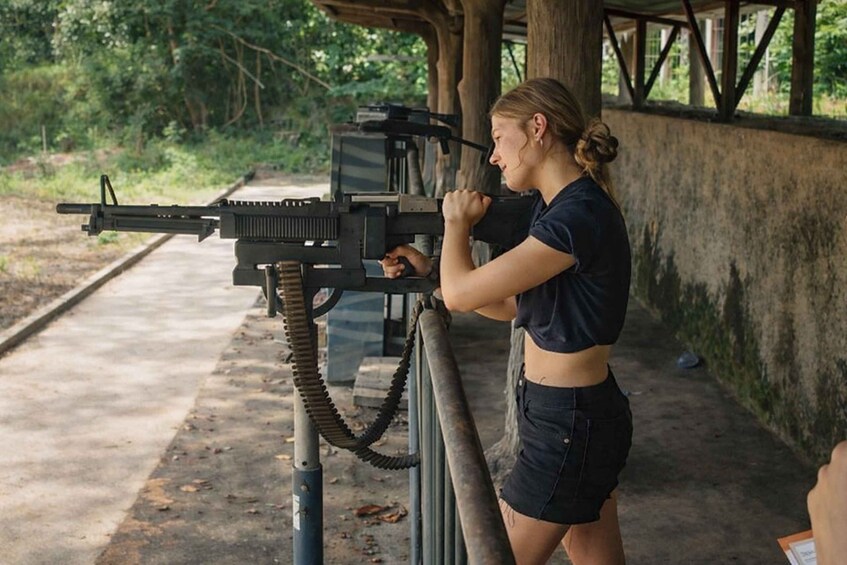 A person aiming a machine gun at a shooting range. 1