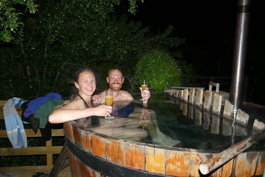 Two people in a hot tub outdoors at night. 2