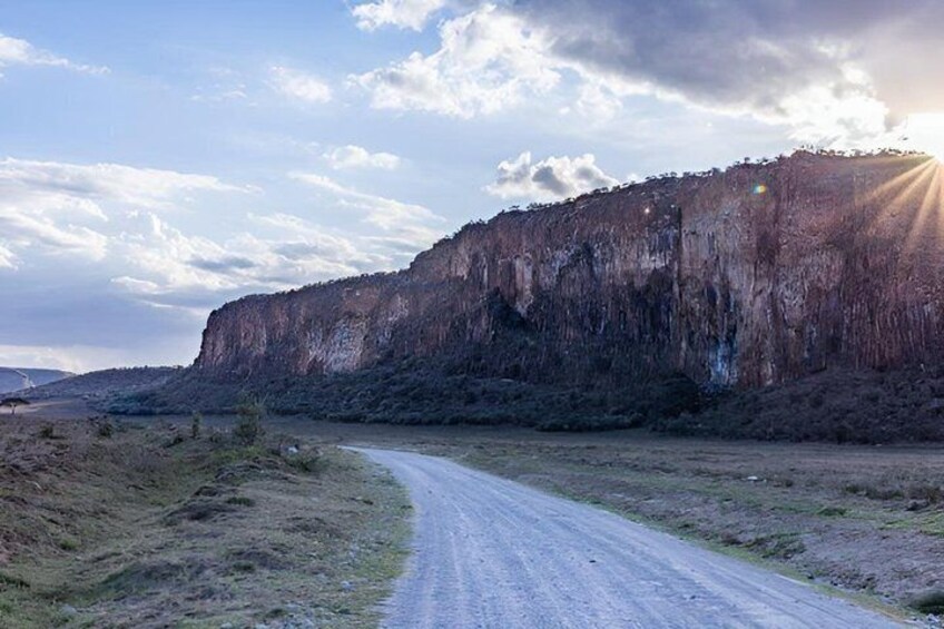 A dirt road curving alongside a steep cliff. 5