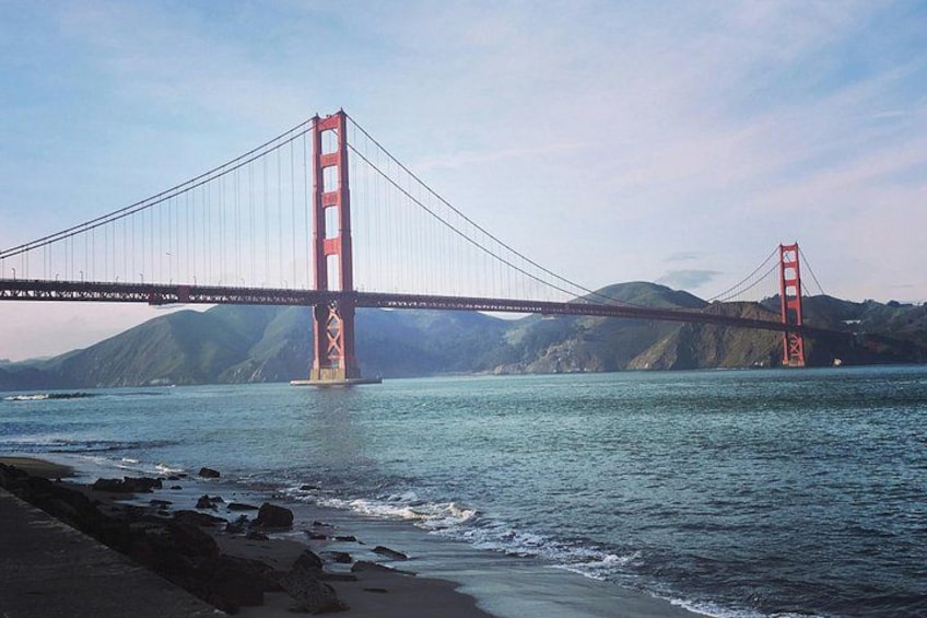 The Golden Gate Bridge spanning a body of water with hills in the background. 5