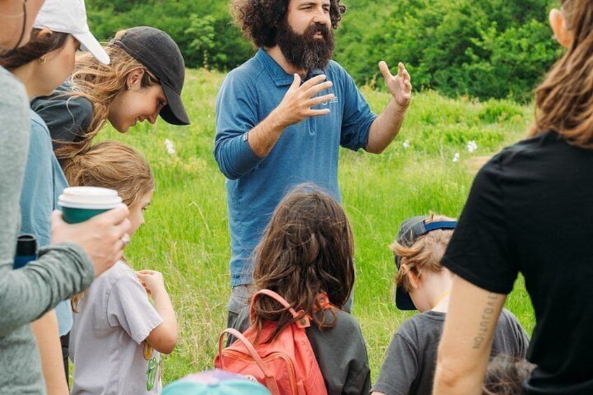 A group of people outdoors, some standing and some sitting, engaged in conversation. 2