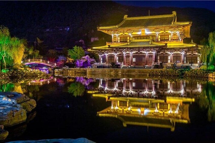A traditional Chinese building with a reflection in the water, surrounded by greenery and a small bridge. 5
