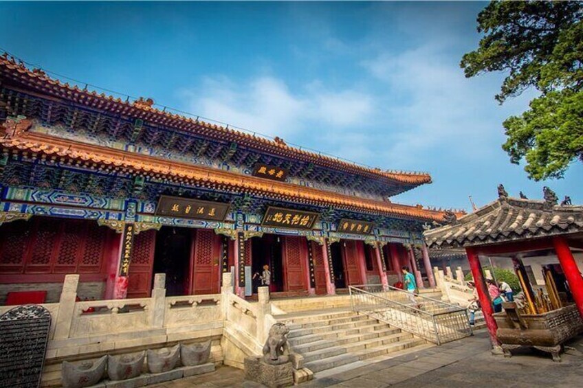A traditional Chinese building with ornate architecture, a stone staircase, and a red-tiled roof. 3