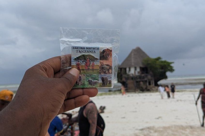 Una mano sostiene un folleto de viajes para Nakuna Matata, Tanzania. 2