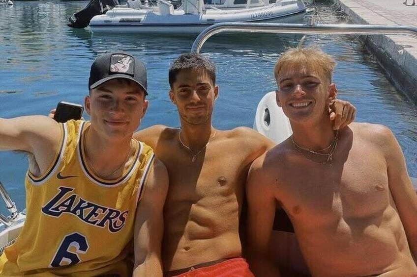 Three people by a pool with a boat in the background. 1
