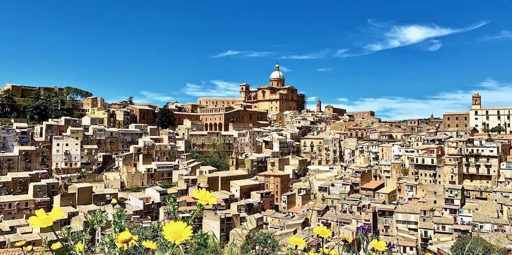 A densely packed urban landscape with historic architecture, including a prominent building with a dome and bell tower. 1