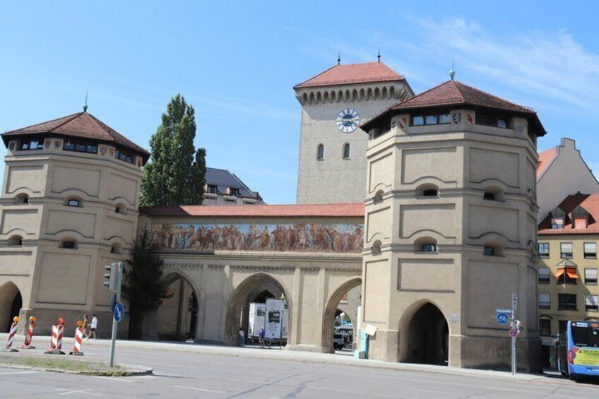 A historic building with arched gateways and a clock tower. 3