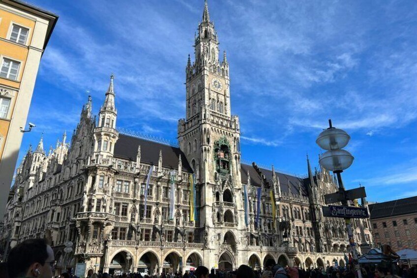 A historic building with intricate architecture, a prominent clock tower, and a clear blue sky. 5