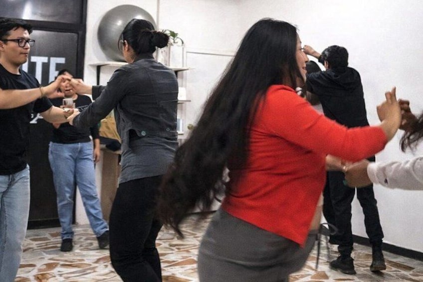 A group of people engaged in a dance activity in an indoor setting with a patterned floor. 5