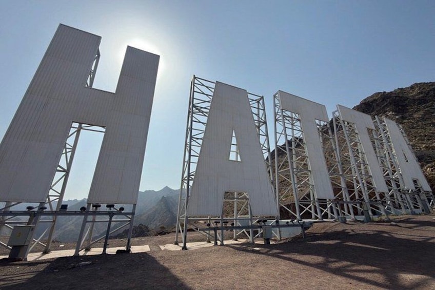 Large metal structures forming the letters 'H' and 'A' with a mountainous backdrop. 1
