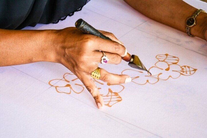 A person drawing floral patterns on paper with a brush. 2