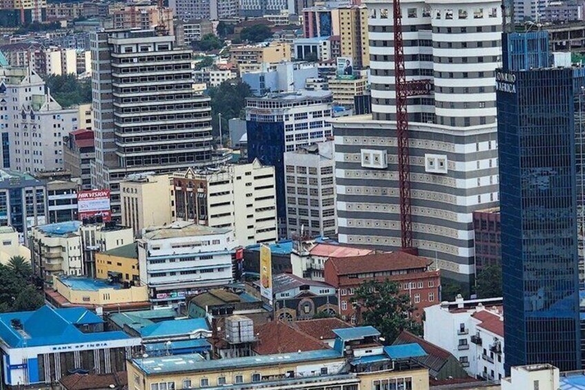Un denso horizonte urbano con rascacielos, incluyendo una torre destacada con una estructura roja. 5