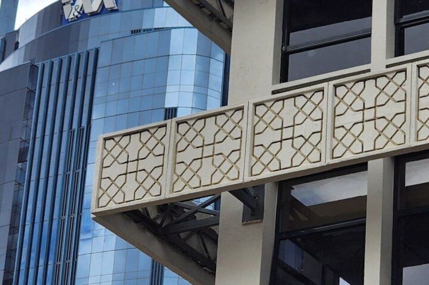 Un edificio moderno con fachada de vidrio y barandilla metálica decorativa. 3