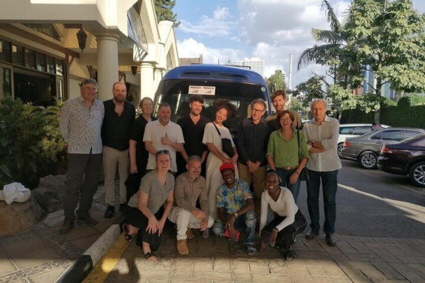 Un grupo de personas posando frente a un vehículo azul con un cartel que dice 'PRODUCE'. 1