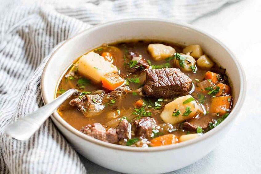 Eine Schüssel Rindfleischeintopf mit Kartoffeln und Karotten. 1