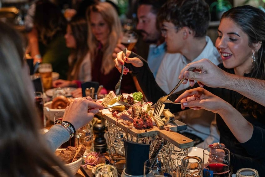 A group of people dining at a buffet with various dishes and drinks. 3