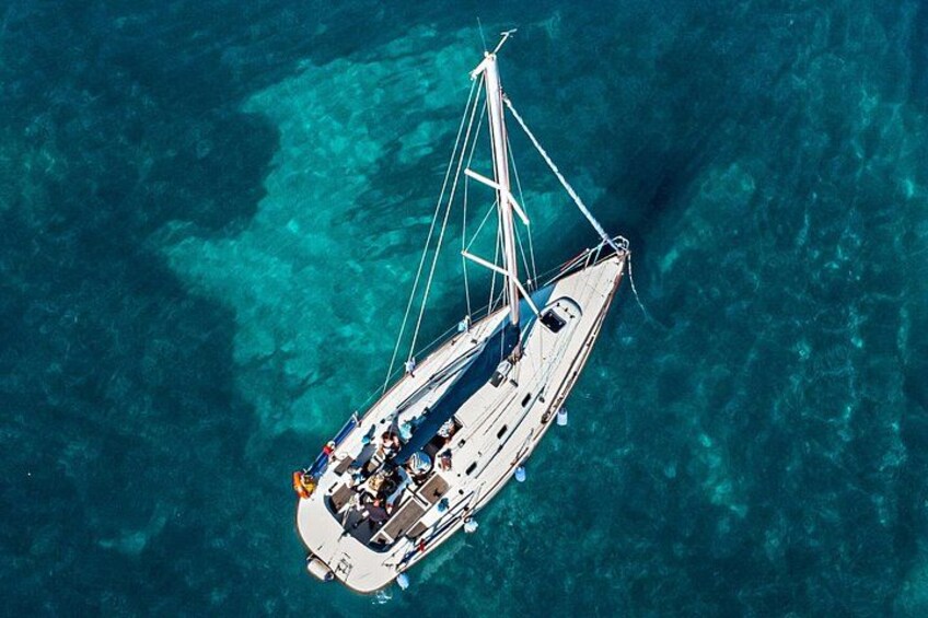 A sailboat on clear turquoise water. 1