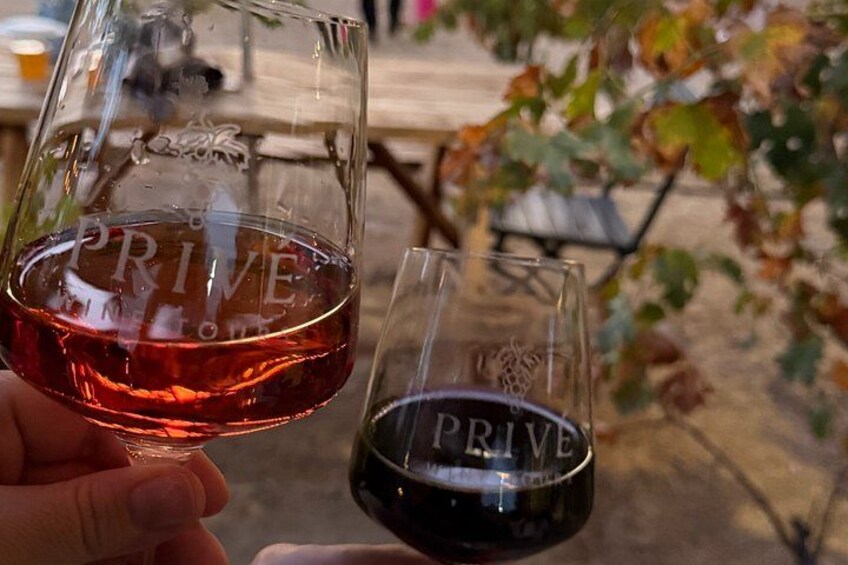 Two wine glasses with the word 'PRIVE' on them, held by a person. 4