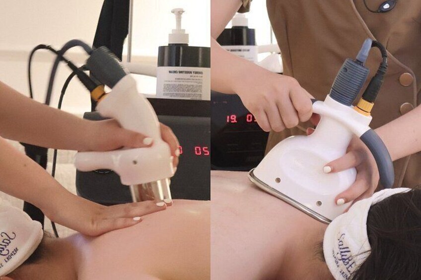 A person receiving a treatment with a handheld device, a bottle of liquid, and a digital timer in the background. 2