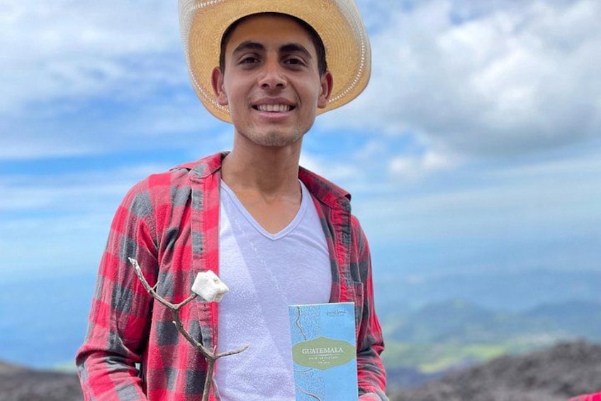 Une personne tenant un livre intitulé « Guatemala », avec un paysage montagneux en arrière-plan. 3