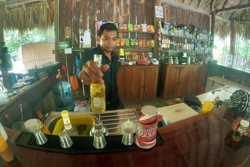 A bar with a counter, bottles, and a sign. 5