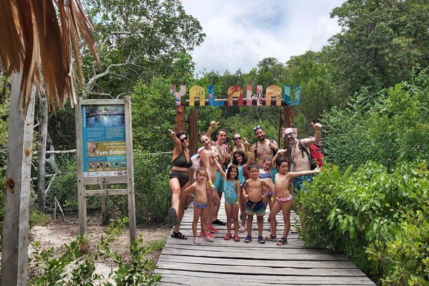 A group of people on a wooden boardwalk with a sign that reads 'Yum Bali.' 4