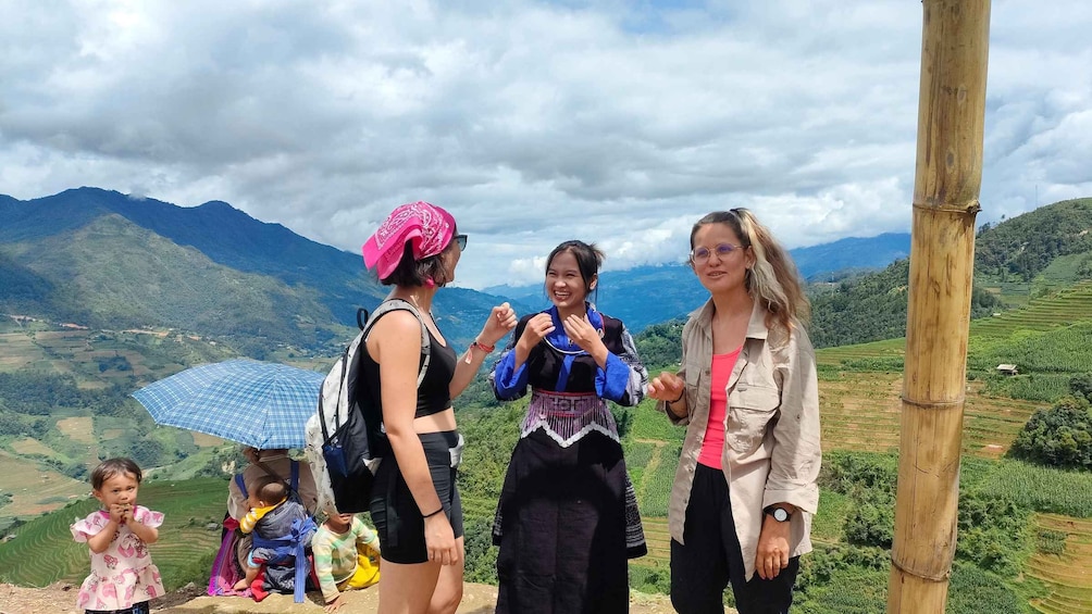 A group of people standing on a hill with a mountainous landscape in the background. 1