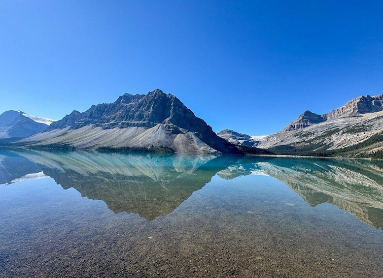 A mountain range with a clear lake reflecting the peaks. 1